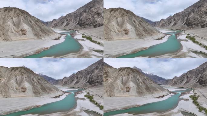 从巴基斯坦北部斯卡都的喀喇昆仑山脉拍摄的卡帕纳寒冷沙漠和被雪帽山包围的印度河的空中无人机视图
