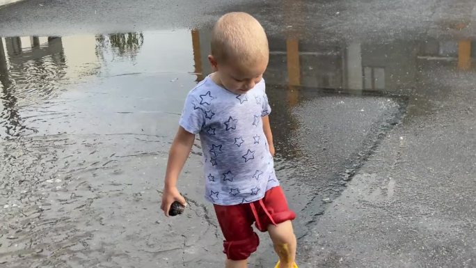 happy toddler child running jumping through puddle