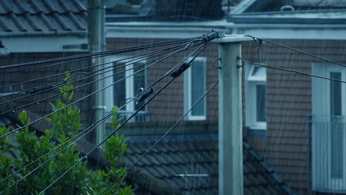 大雨打在房屋和电线杆上