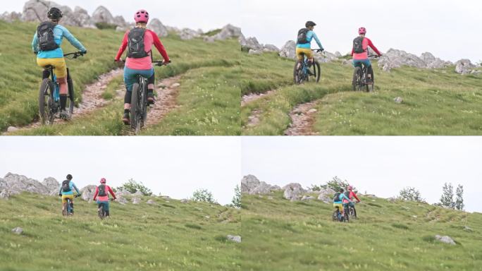 两名女山地自行车手骑着他们的电动自行车沿着山路而下