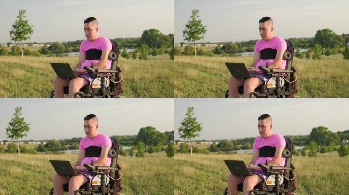 坐在轮椅上的男子在草地上用现代笔记本电脑工作