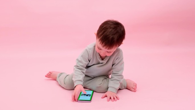 Happy toddler baby with mobile phone on studio pin