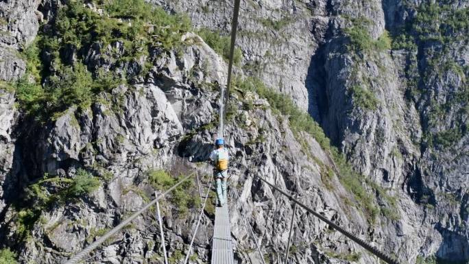 一名男子穿过挪威费拉塔大道上的吊桥