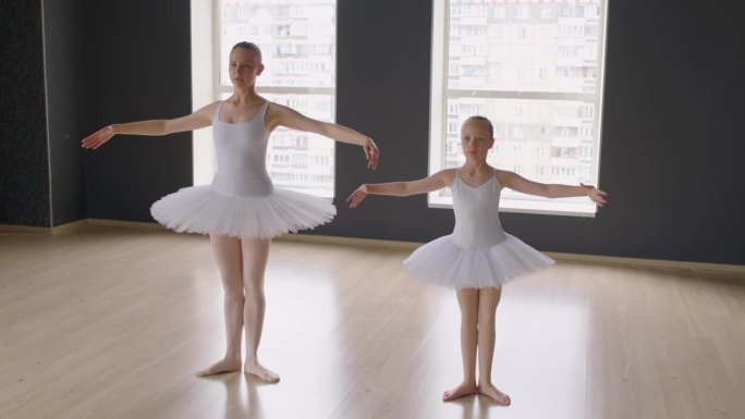 女孩在老师的帮助下学习经典芭蕾动作