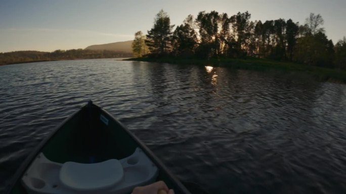 户外探险:在日落时分在湖中划独木舟