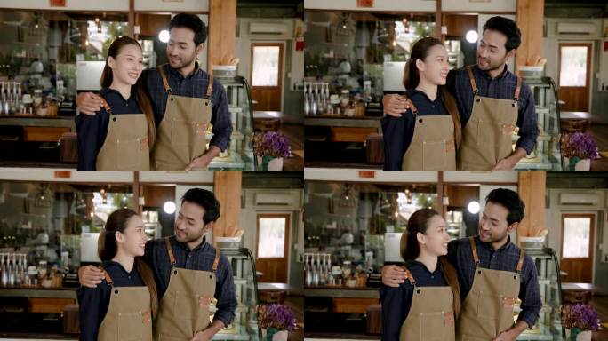 肖像亚洲丈夫妻子咖啡师，站在拍摄视频宣传他们的咖啡馆，男子转身亲吻女友前举起手温暖抚摸头，深情地看着