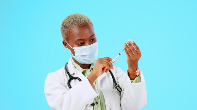 Covid，疫苗和医生，蓝色背景的黑人女性在医疗保健或治疗工作室工作。医疗、保险和口罩，由一名女医学