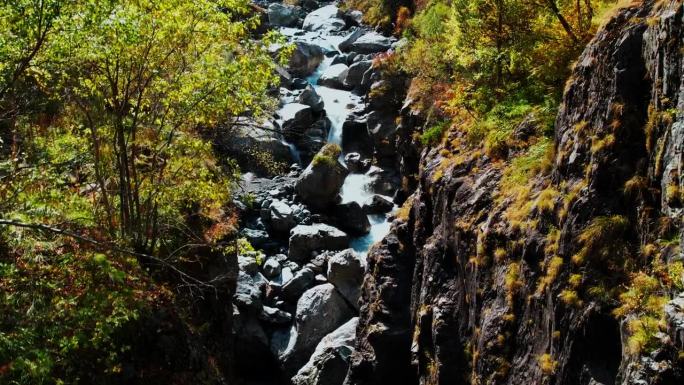 小河从山峰上流过，流过山谷里的石头，航拍