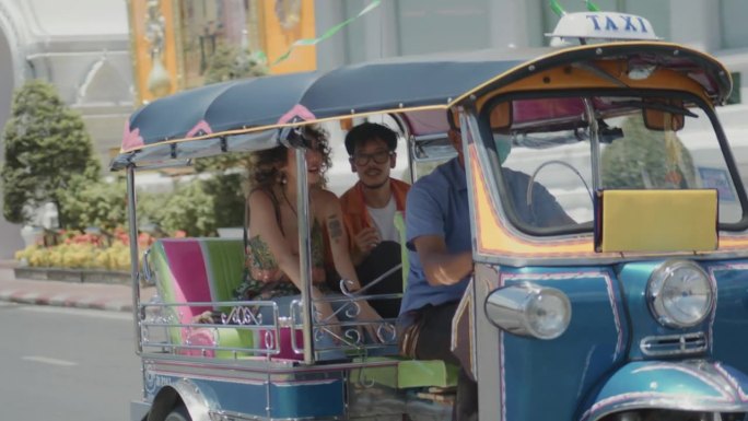 亚洲游客一起乘坐嘟嘟车在曼谷旅游，男女朋友在泰国的城市街道上享受和享受户外生活方式。