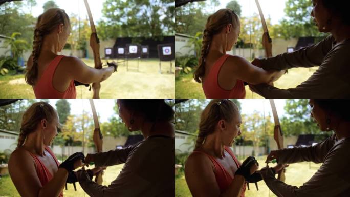 女子在射击场拿着弓。泰国游客户外娱乐场所。在射击场练习射箭。假期积极休闲，到亚洲旅游。木弓，箭命中目