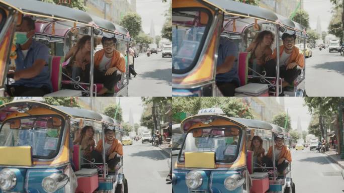 一对夫妇在泰国曼谷愉快地乘坐电动汽车Tuk Tuk旅行。