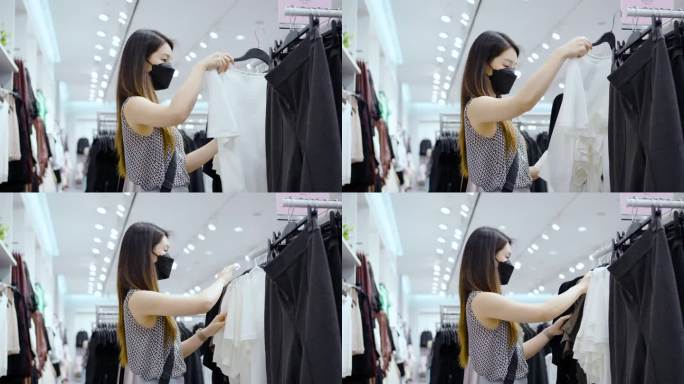 一位戴口罩的妇女在布店挑选衣服