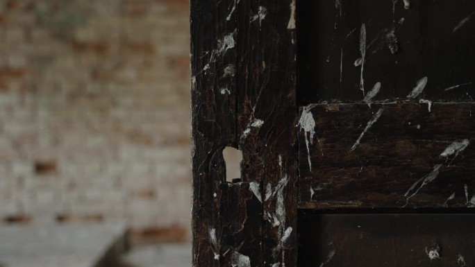 旧木门上有裂缝的空锁孔，特写。