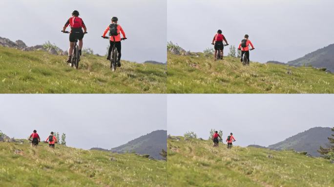 两个女人在阳光明媚的山上骑着电动山地车