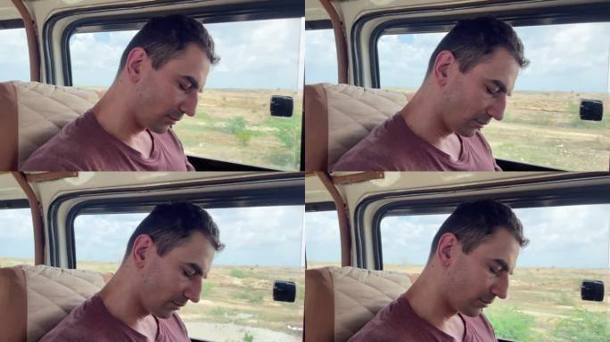 一名疲惫的游客乘吉普车在非洲狩猎时在车里睡着了