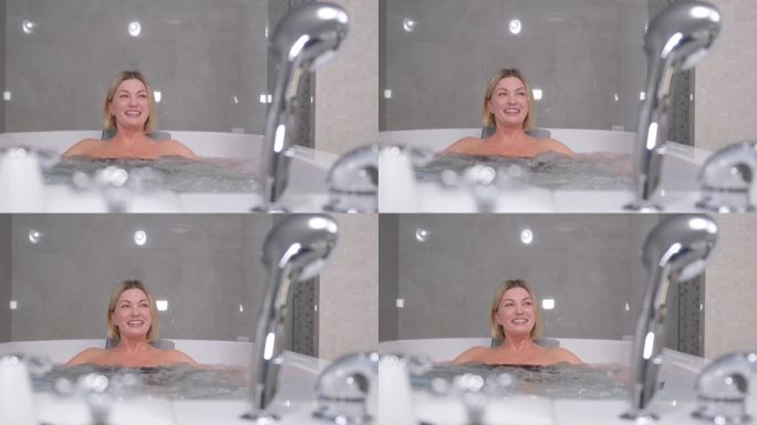一个面带微笑的金发女人在泡热水澡。