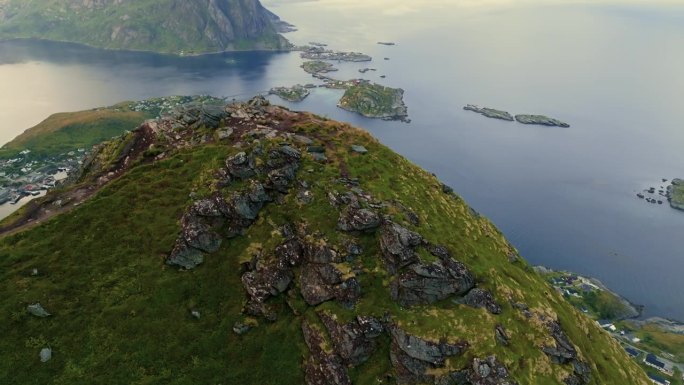 无人机飞过峡湾的山顶，展现挪威小渔村的美丽全景