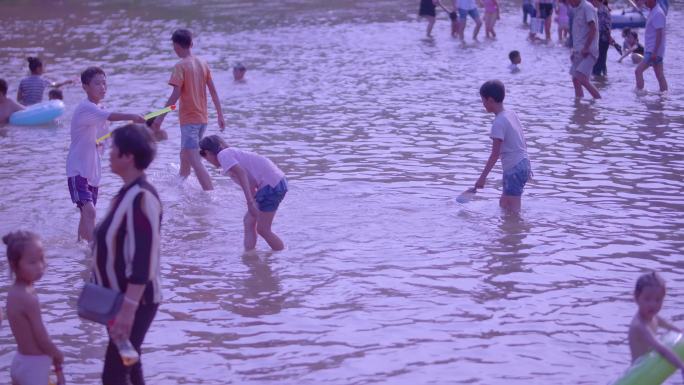 孩子在小河流里玩水玩耍凉快