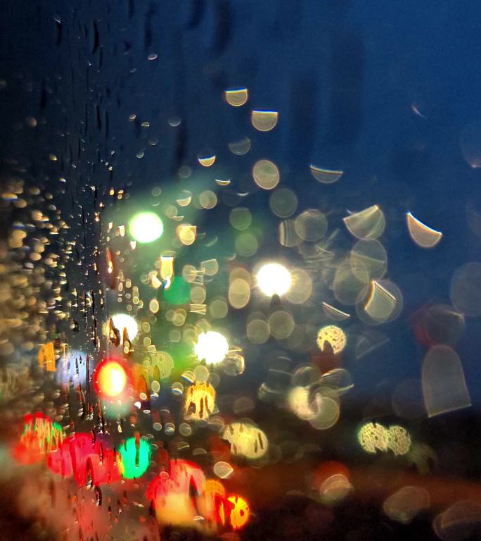 夜晚灯光下雨中行驶的车窗玻璃水珠空镜