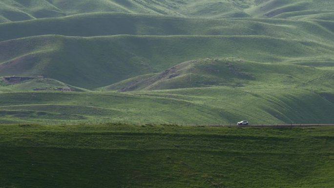 汽车行驶在新疆伊犁阿克塔斯草原
