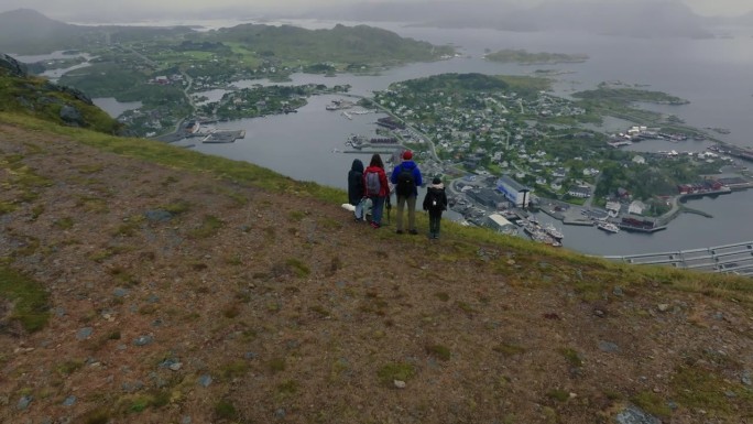 年轻的背包客家庭带着孩子和白狗一起探索迷人的北欧景色。从上面看。