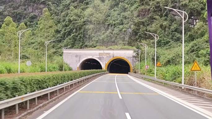 汽车开过隧道高速路进入隧道公路两旁风景