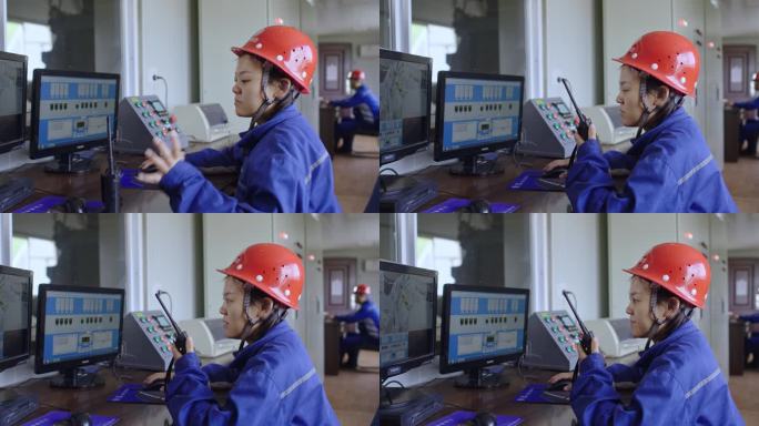 女工程师用电脑和对讲机远程控制机器设备