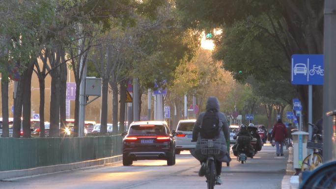 城市街道车流骑行下班回家夕阳下的城市街道