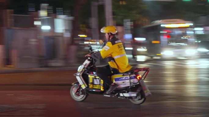 夜晚外卖员骑电动车送外卖