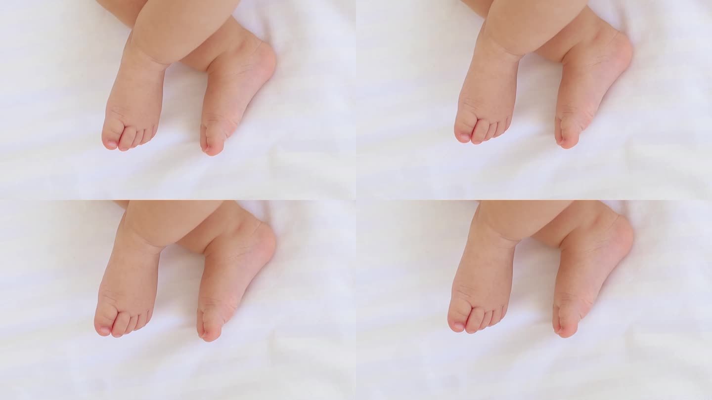 宝宝的小脚在白色的床上，一个文字的地方，一个小婴儿的脚的特写
