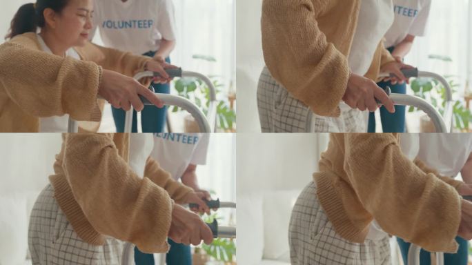 年轻的亚洲女性志愿者教老妇人走路，使用助行器照顾老人，在家里的客厅里牵手老人。志愿医疗保健。