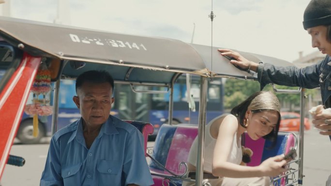 快乐的亚洲夫妇拥抱泰国文化:在曼谷的嘟嘟车冒险后通过智能手机付款。