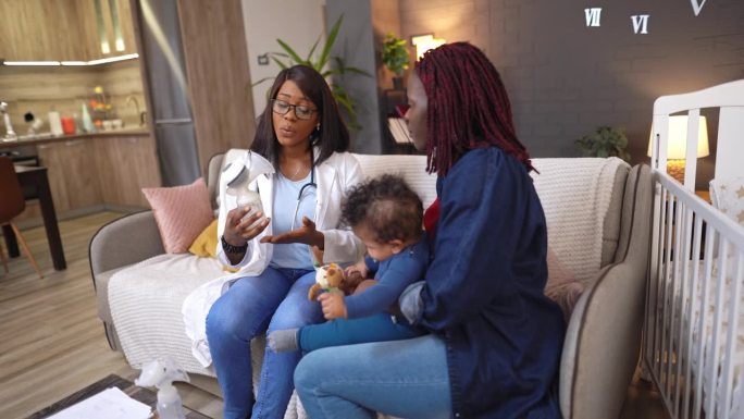 黑人女医护人员到家中看望母子，向母亲讲解吸奶器