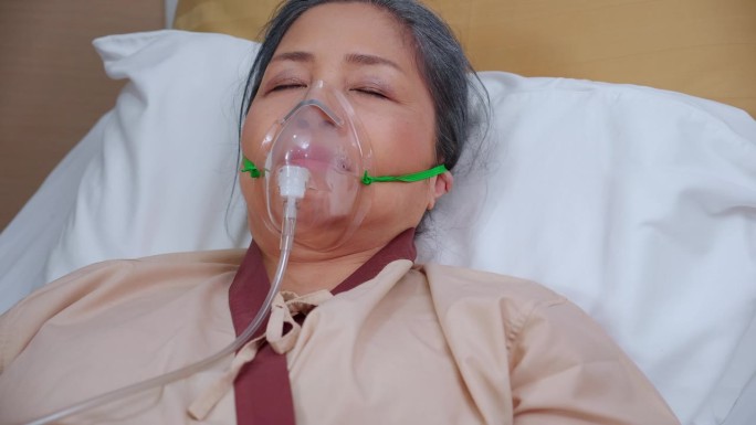 住院病房病床上带着氧气面罩熟睡或昏迷的老年病人，急症室急症的老年病人，呼吸与肺，健康与医药，保险与医