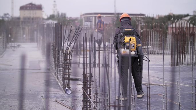 工人使用燃气鼓风机清理建筑工地