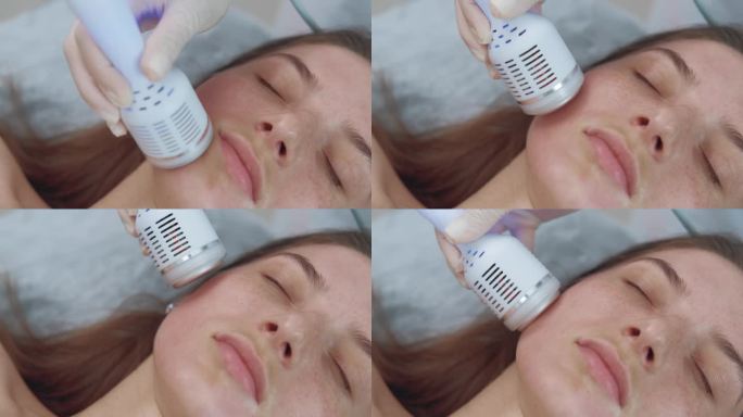 近距离镜头的美容师使用冷冻疗法提升按摩，以恢复和提升病人的皮肤