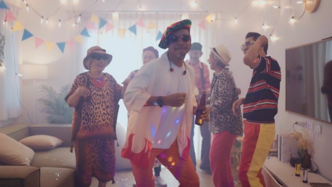 在派对上，穿着五颜六色衣服的亚洲男人拿着啤酒，伴着他们最喜欢的歌曲跳舞。