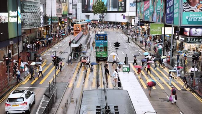 下雨天，香港铜锣湾的游客走过斑马线。