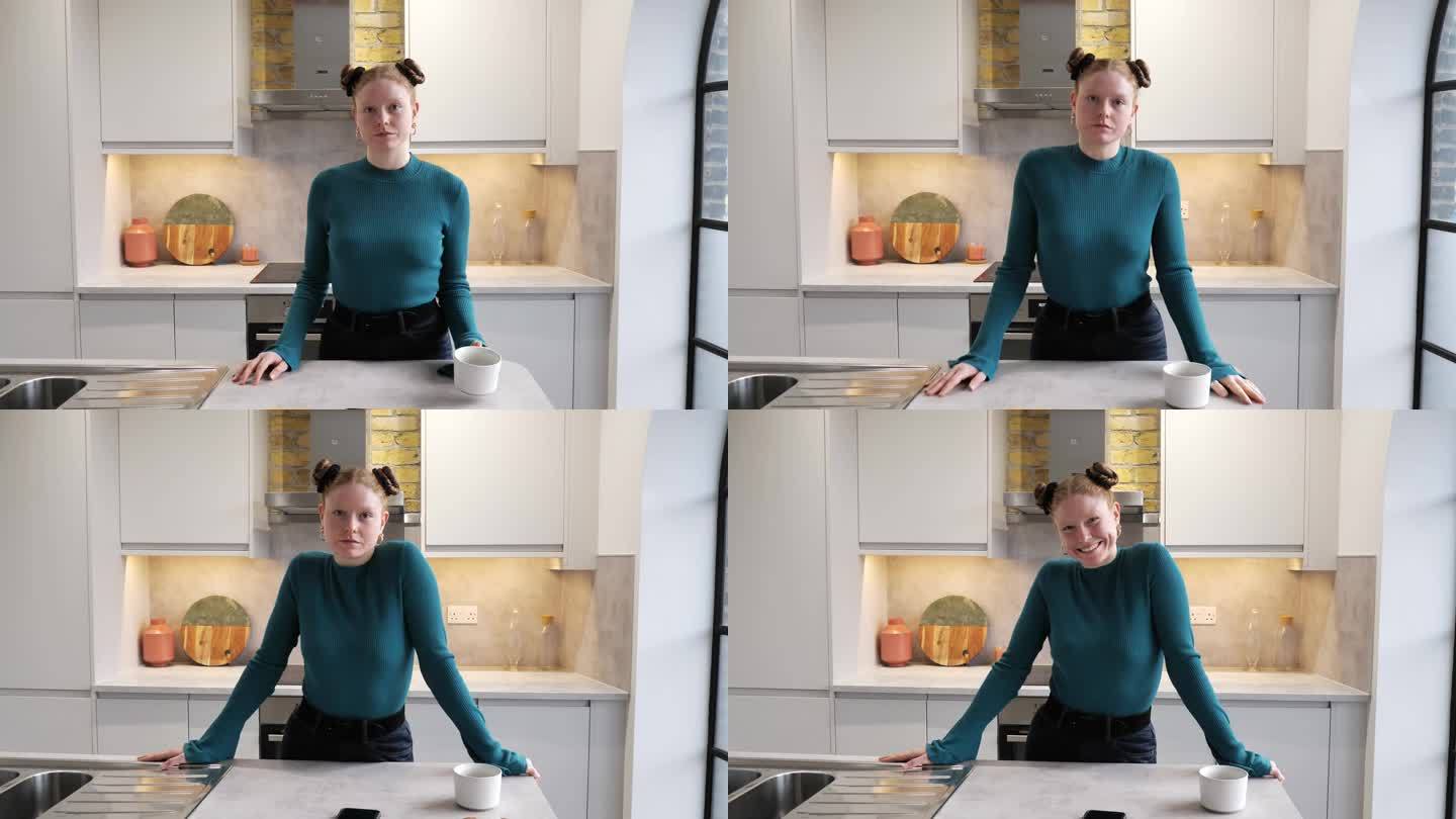 红发女人站在厨房柜台后面看着摄像机，4k视频