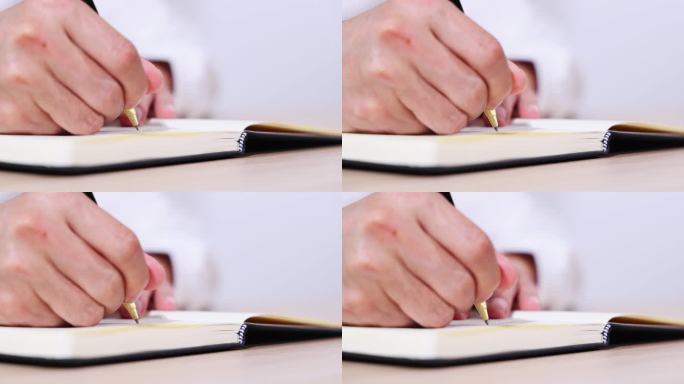在笔记本上书写的手部特写