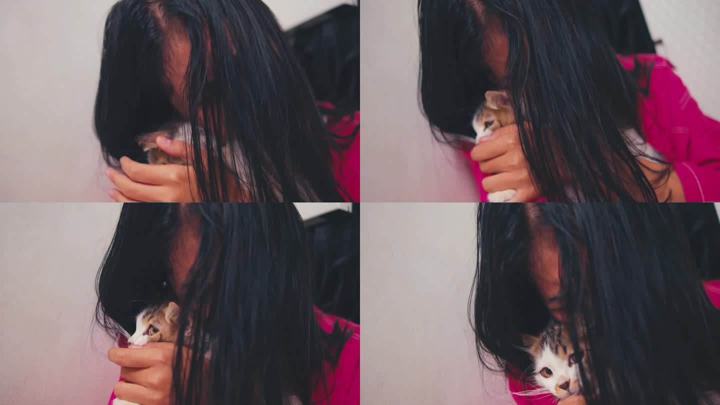 一名亚洲妇女因为受到家人的欺负，在抱着一只猫的时候哭得很伤心