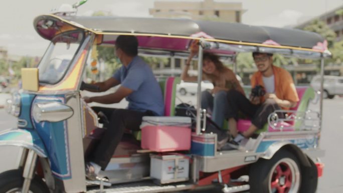 甜蜜的夫妇在泰国曼谷度过了一段特殊的时光，愉快地乘坐嘟嘟车旅行。