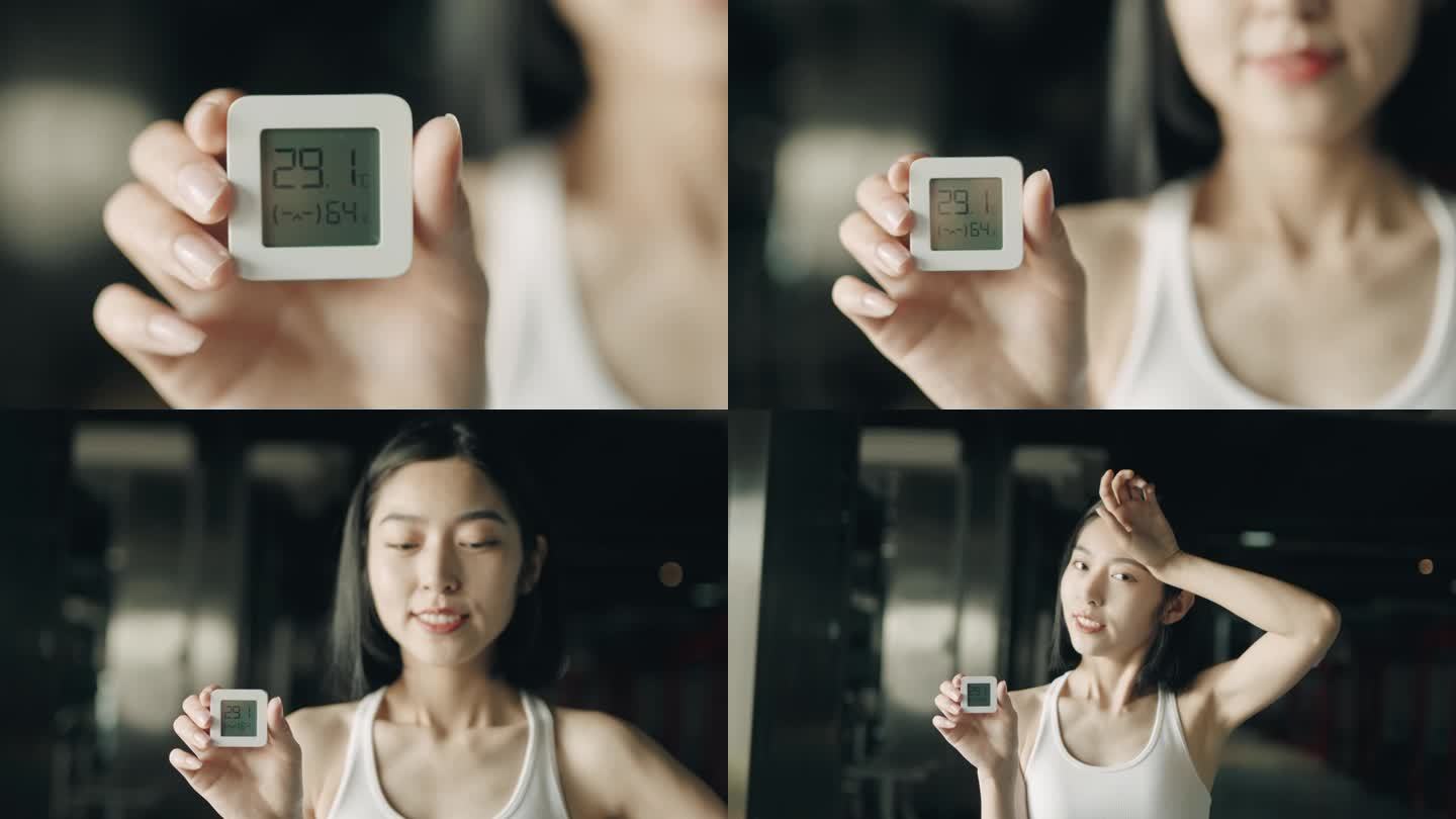 一个年轻的亚洲女人拿着电子体温计