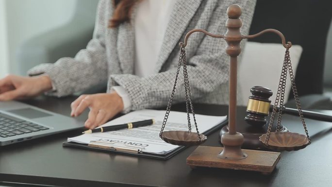 法律顾问用木槌和法律条文向客户出示已签署的合同。正义与律师观念。