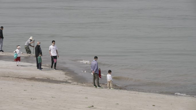 武昌江滩上在江边捞鱼玩耍的人
