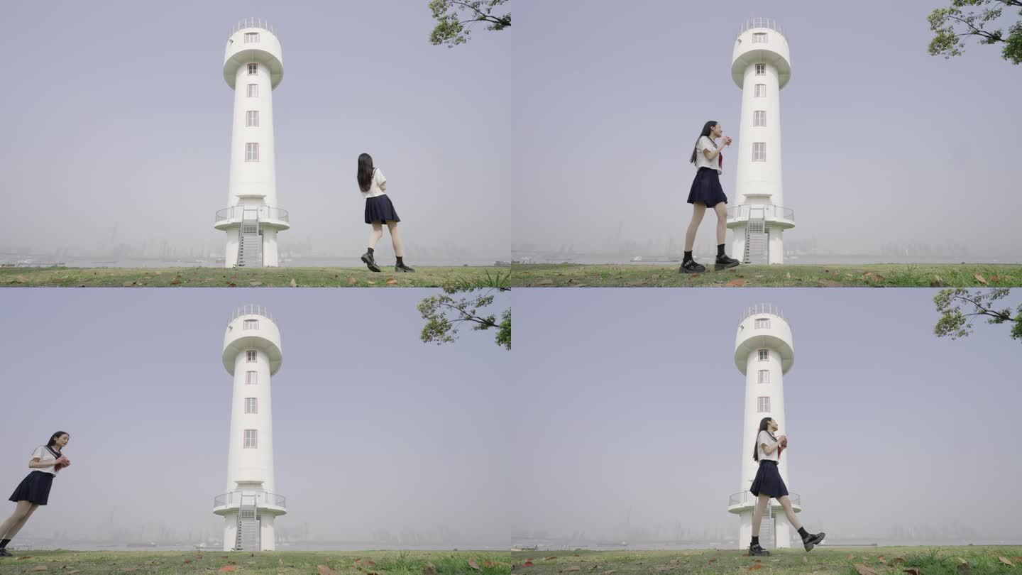 女生从武昌江滩小垦丁江边的白色灯塔前走过