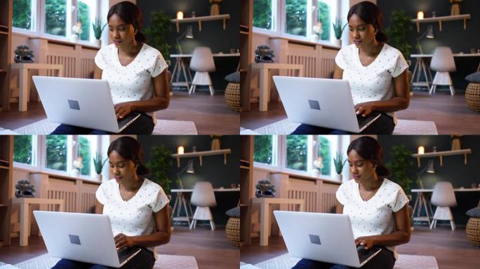年轻的黑人女性在家里用笔记本电脑工作