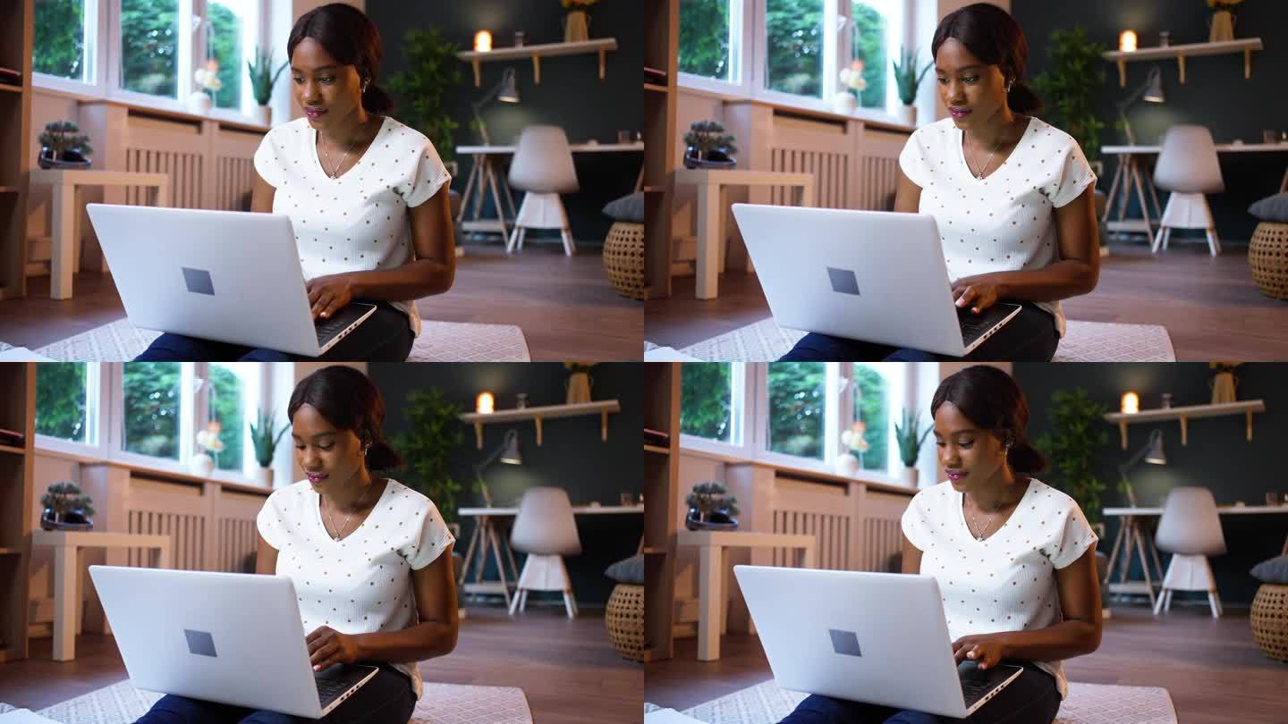 年轻的黑人女性在家里用笔记本电脑工作