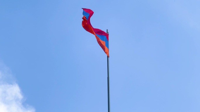 刮风的天气里，亚美尼亚国旗在晴朗的蓝天上飘扬