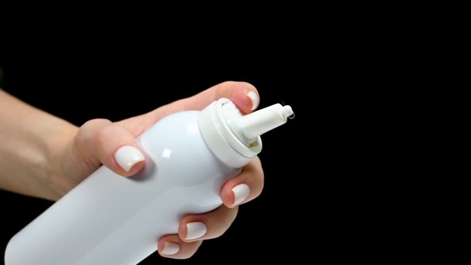 白色瓶子喷雾剂用于鼻子鼻在手